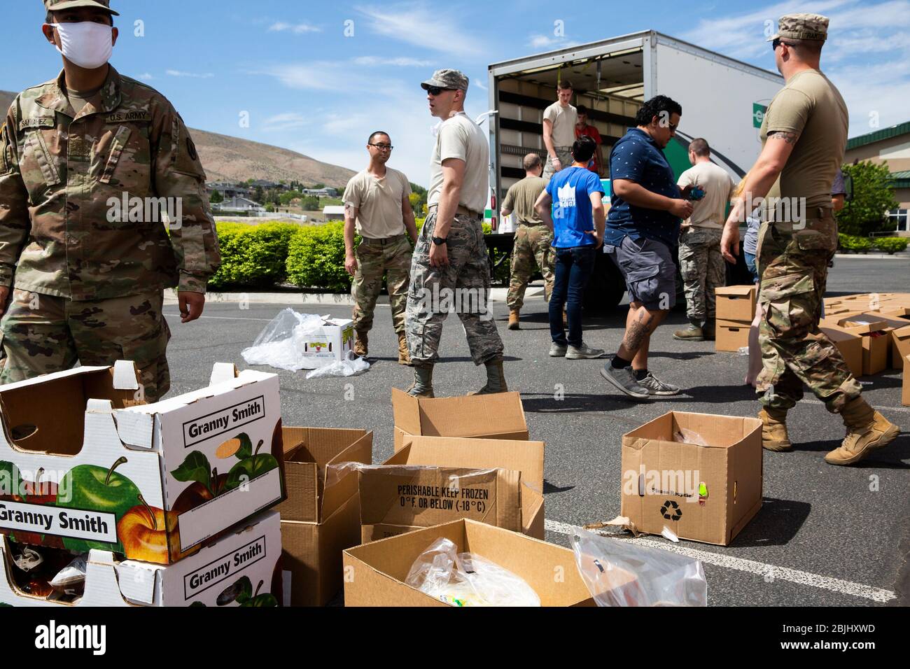 Volunteers from Bethel Church and Second Harvest food bank work with Washington National Guard soldiers to distribute boxes of free food to residents Stock Photo