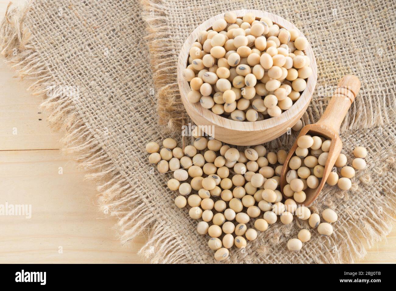 soybean in wood cup  on sack background Stock Photo