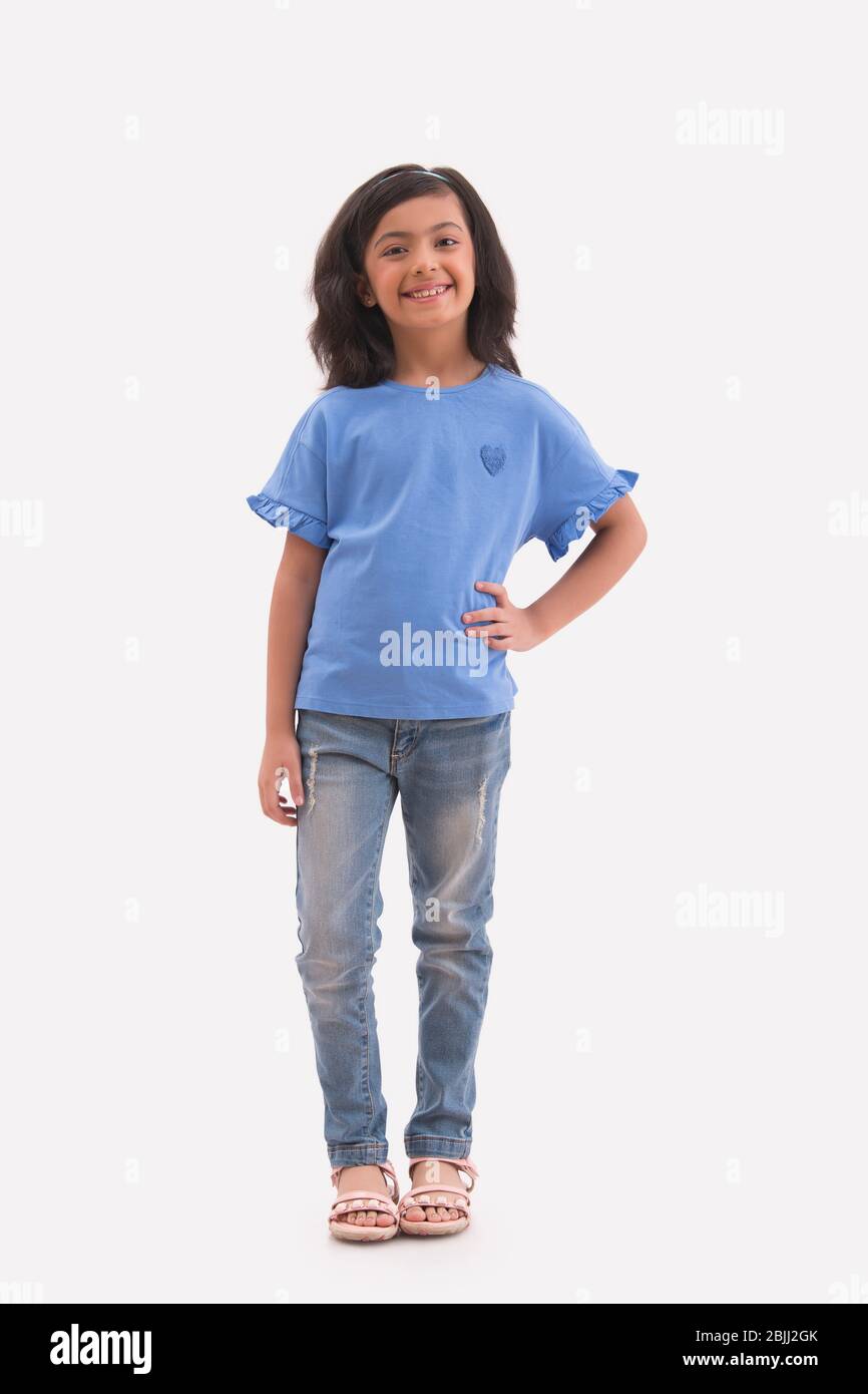 Happy young girl standing with a hand on her waist. (Children) Stock Photo