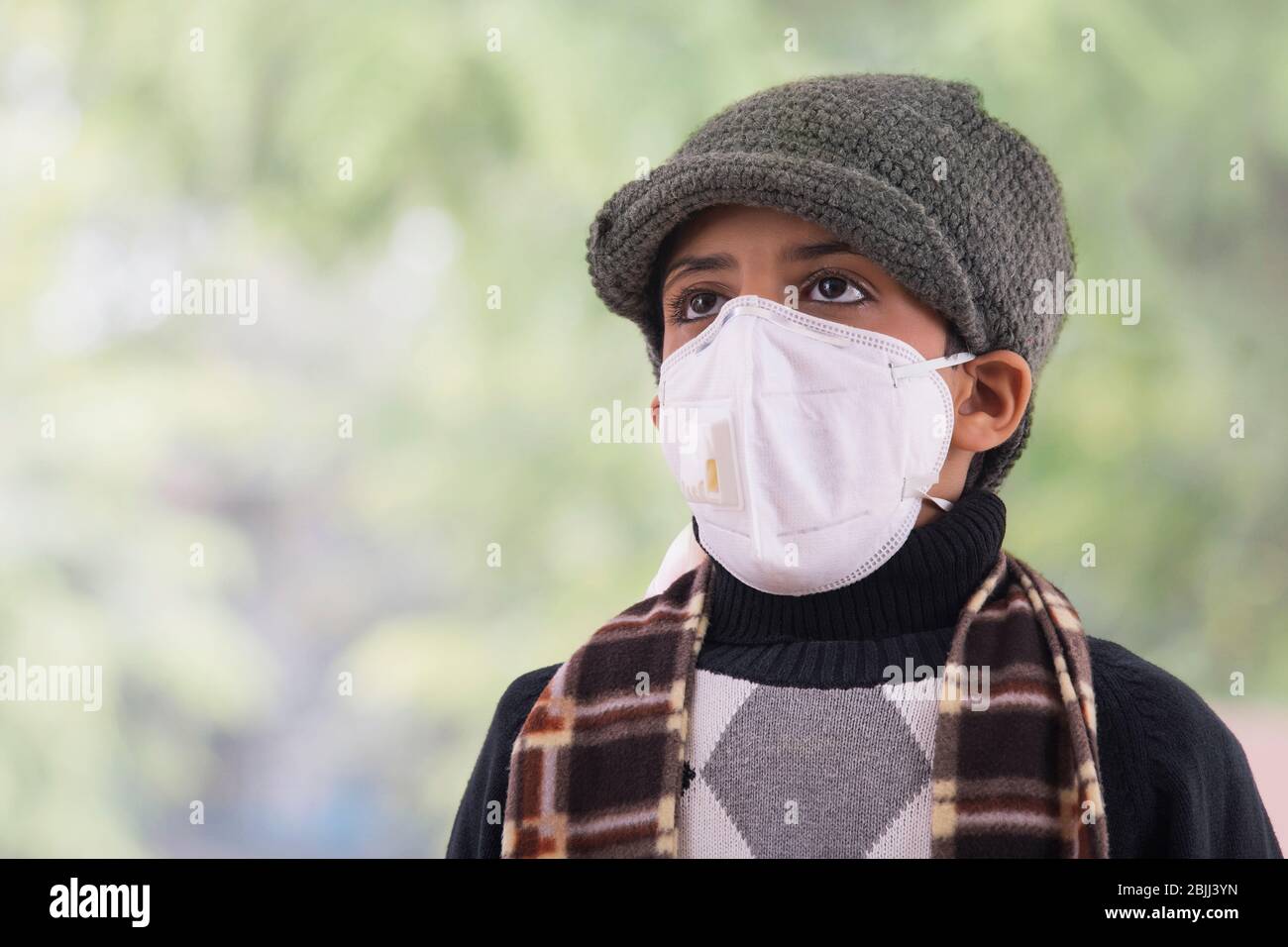 Young boy wearing a pollution mask and winter clothes. (Children) Stock Photo