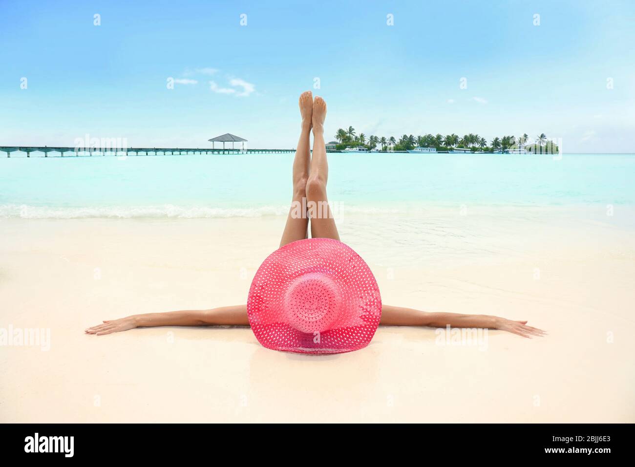 Beautiful young woman lying on beach at resort Stock Photo - Alamy