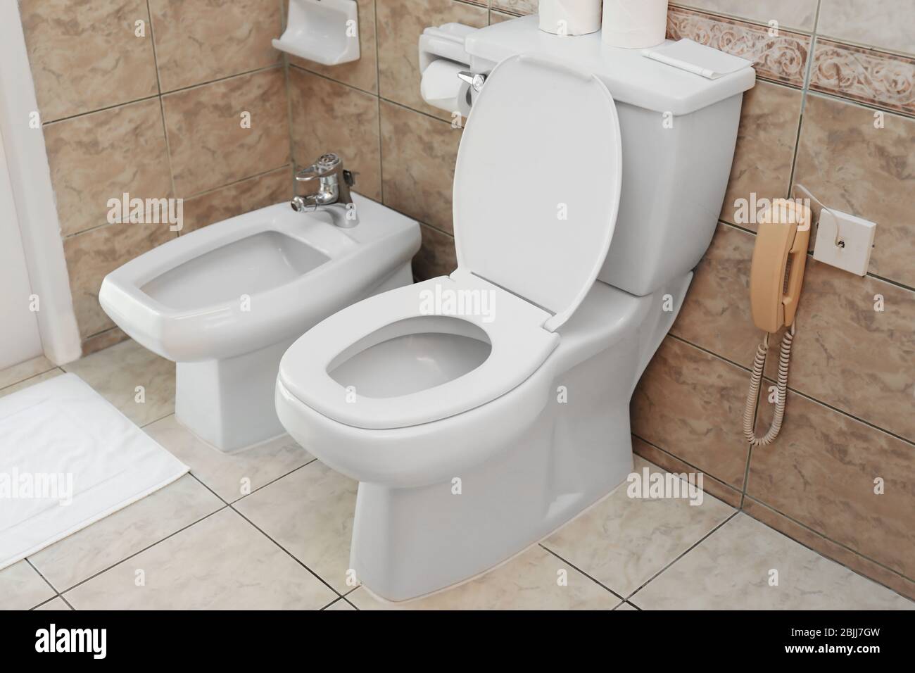 Toilet bowl and bidet in light modern bathroom Stock Photo - Alamy