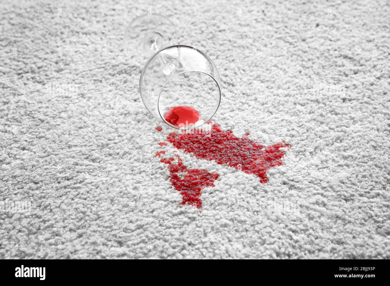 Glass of red wine spilled on white carpet Stock Photo Alamy