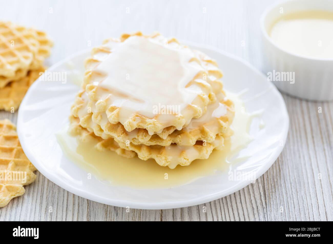 Sweet Condensed or evaporated milk and waffles on a table. A delicious Breakfast. Stock Photo