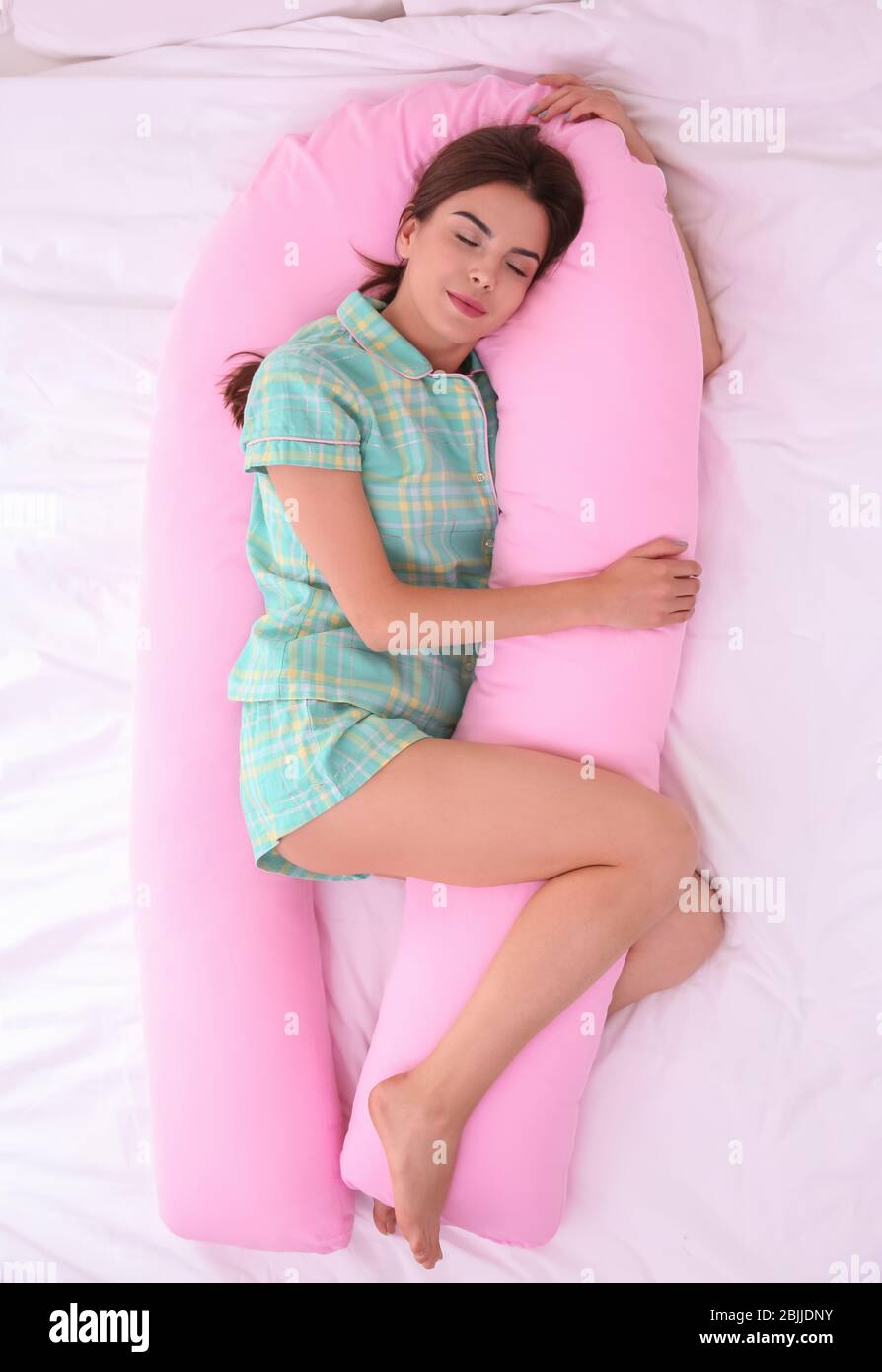 Young beautiful woman sleeping on body pillow in bed Stock Photo Alamy