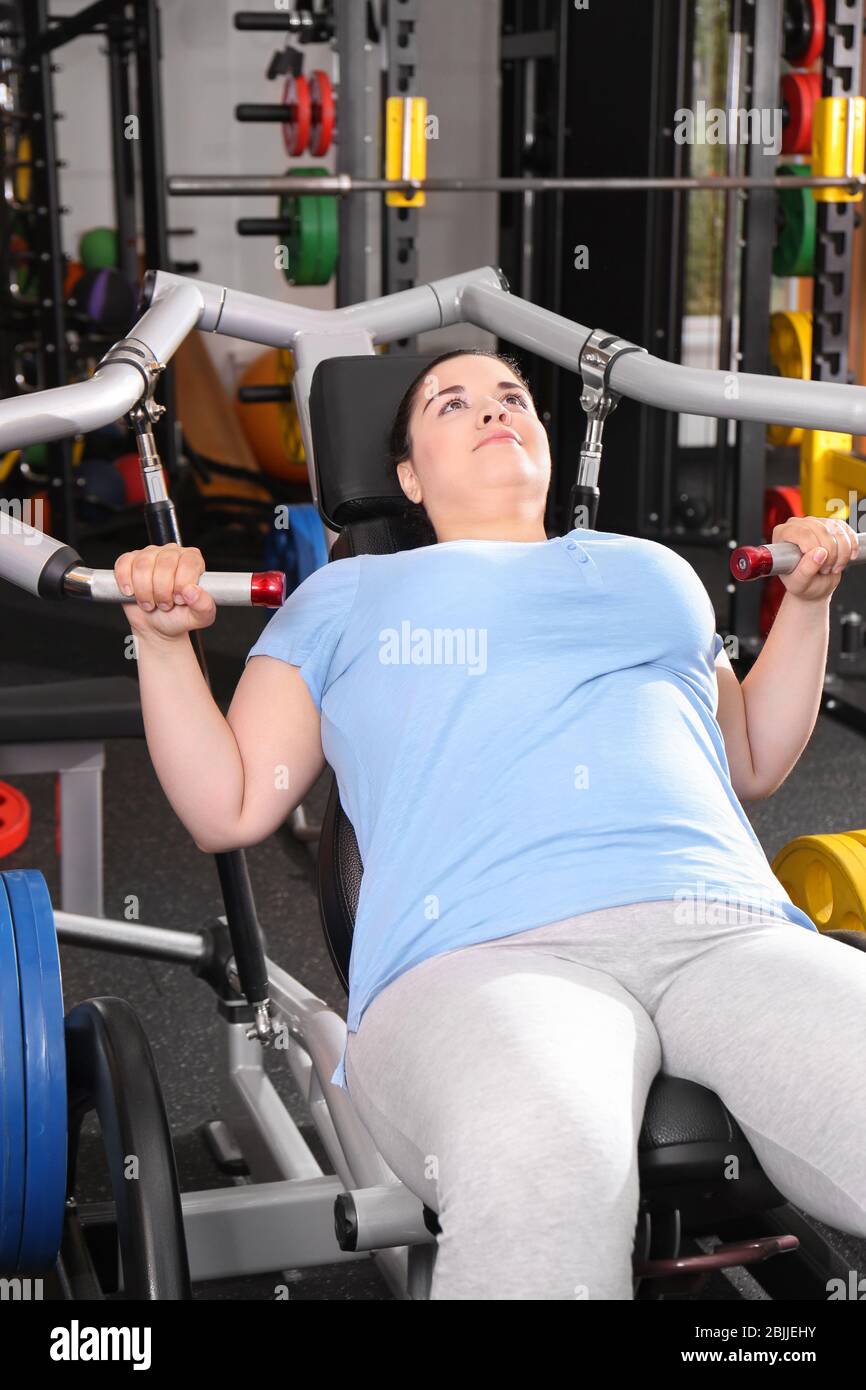 Overweight young woman training in gym Stock Photo
