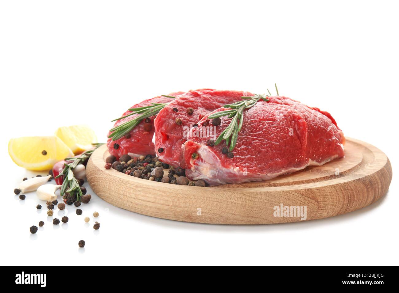 Wooden board with fresh raw meat and spices on white background Stock ...