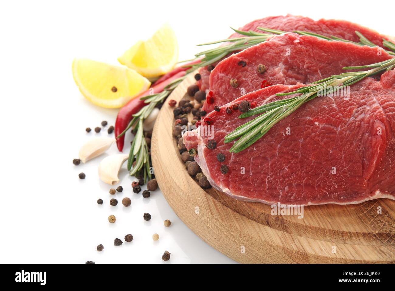Wooden board with fresh raw meat and spices on white background Stock ...