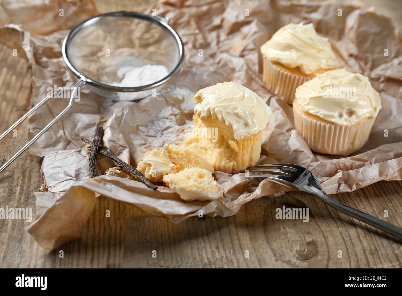 Tasty vanilla cupcakes on parchment paper Stock Photo Alamy