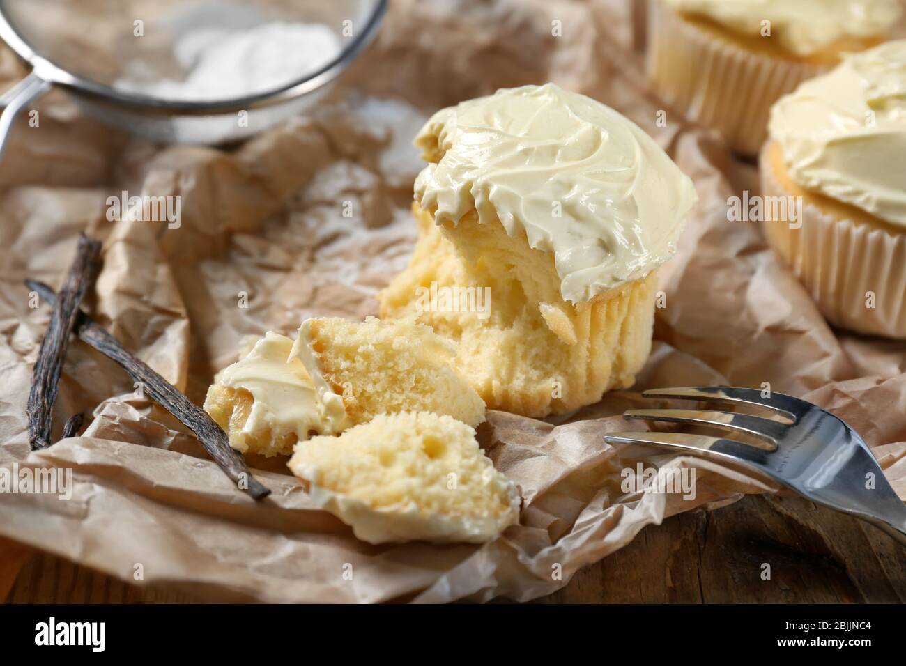 Tasty vanilla cupcake on parchment paper Stock Photo Alamy