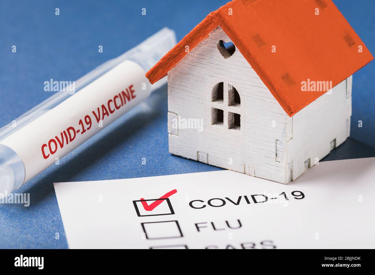 Vaccine, toy house and form with confirmed result on coronavirus. Concept on home treatment covid-19 Stock Photo