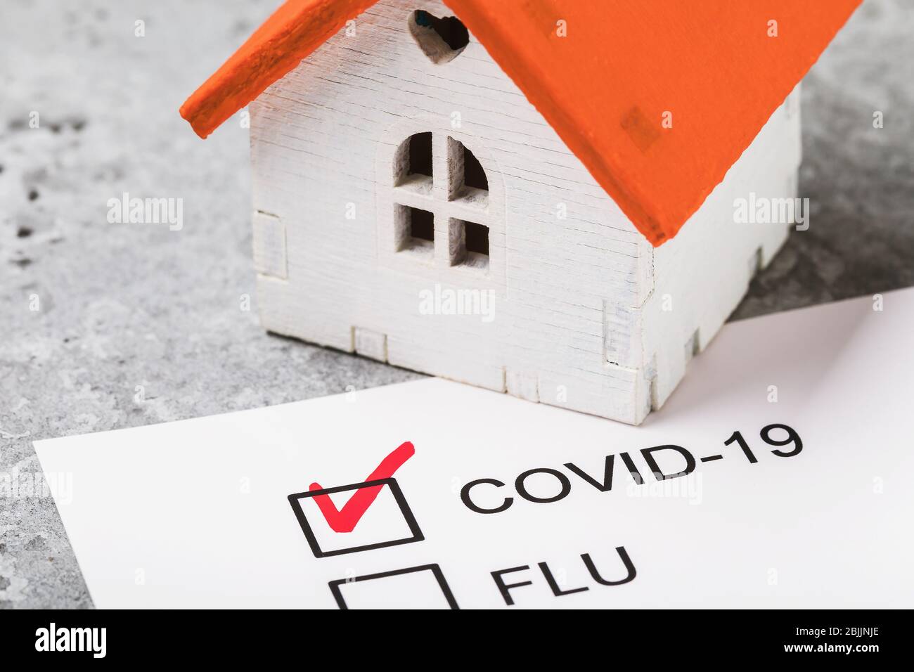 Toy house on the table and form with confirmed result on coronavirus. Home treatment concept covid-19 Stock Photo