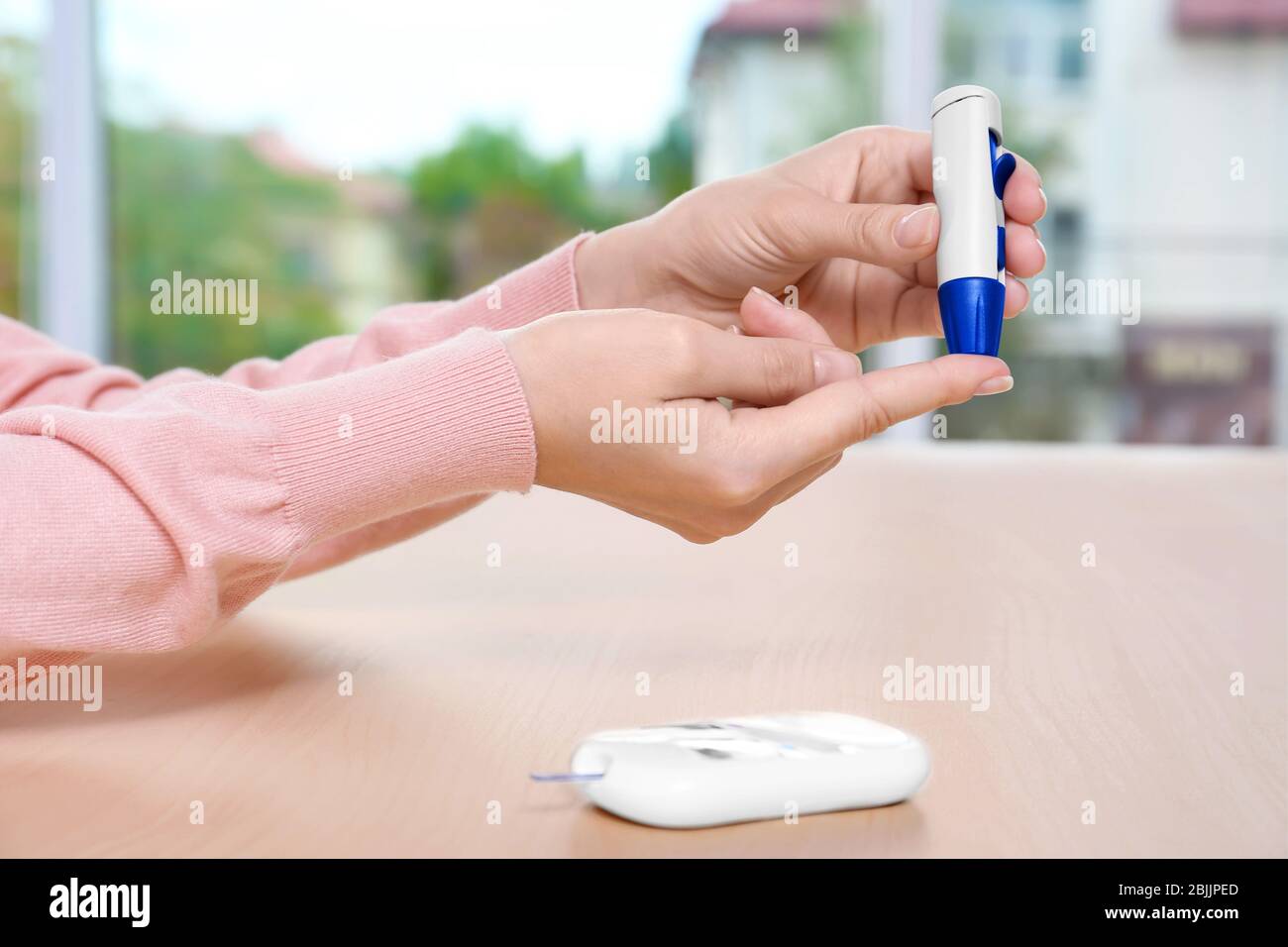 Woman taking blood sample with lancet pen Stock Photo Alamy