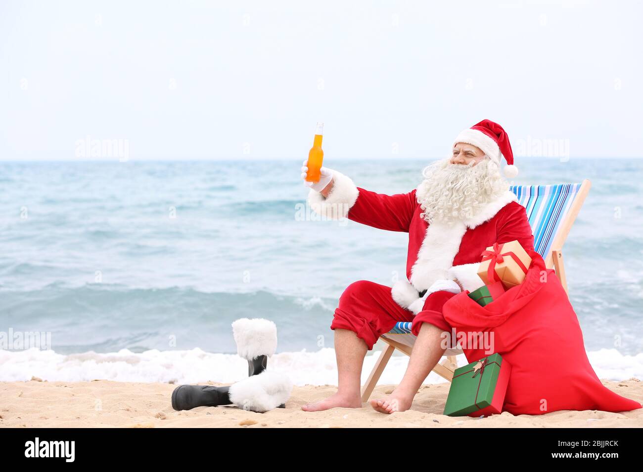 Authentic Santa Claus with bottle of drink and red bag relaxing on ...