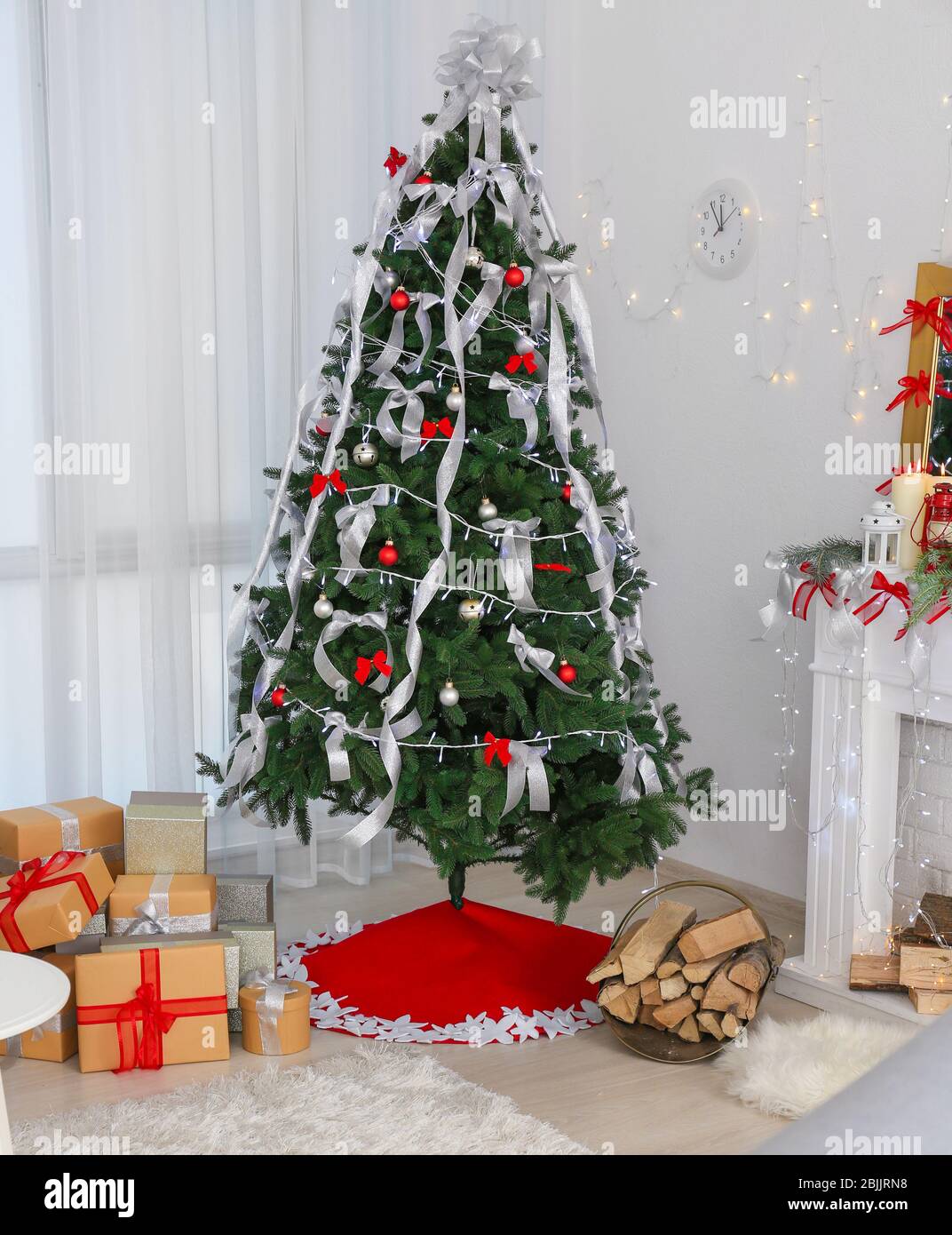 Beautiful Christmas tree with skirt and gifts at home Stock Photo - Alamy