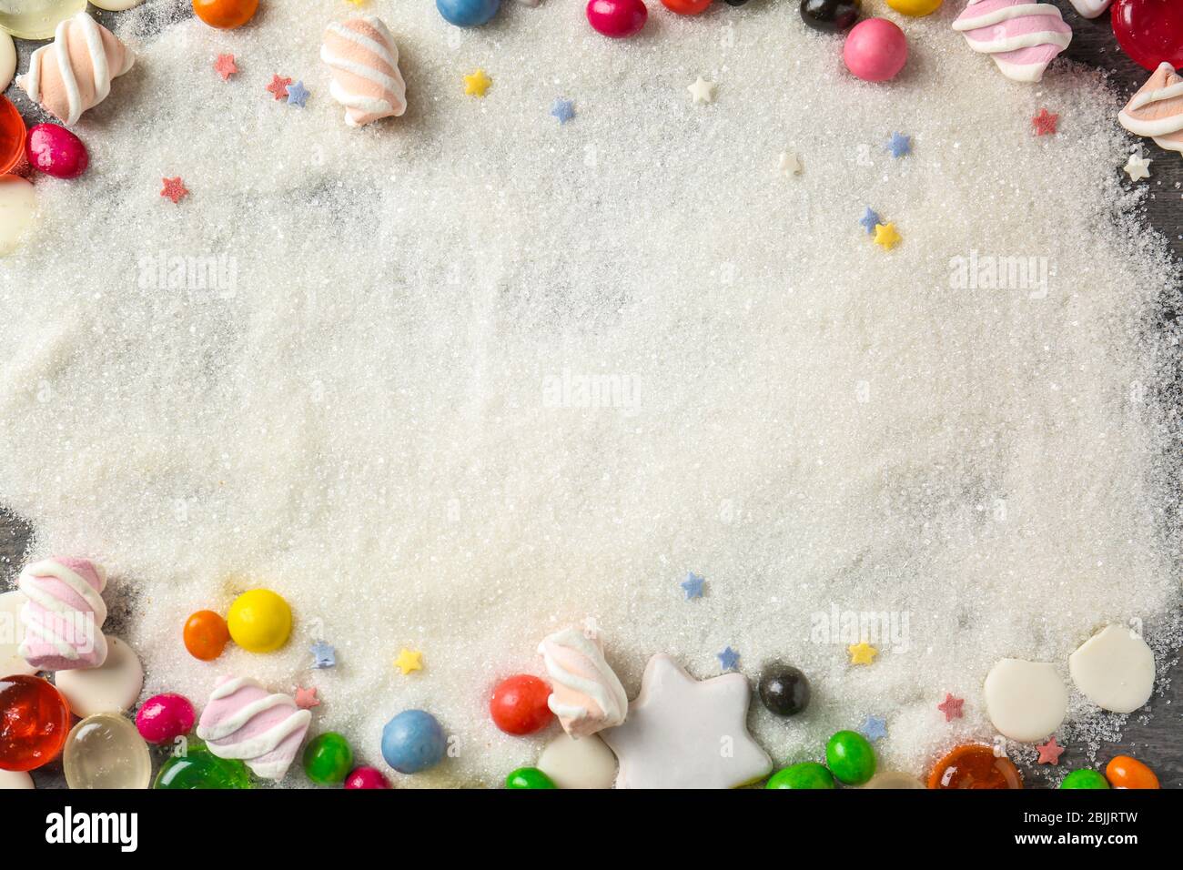 Frame made of colorful candies on sugar background Stock Photo - Alamy