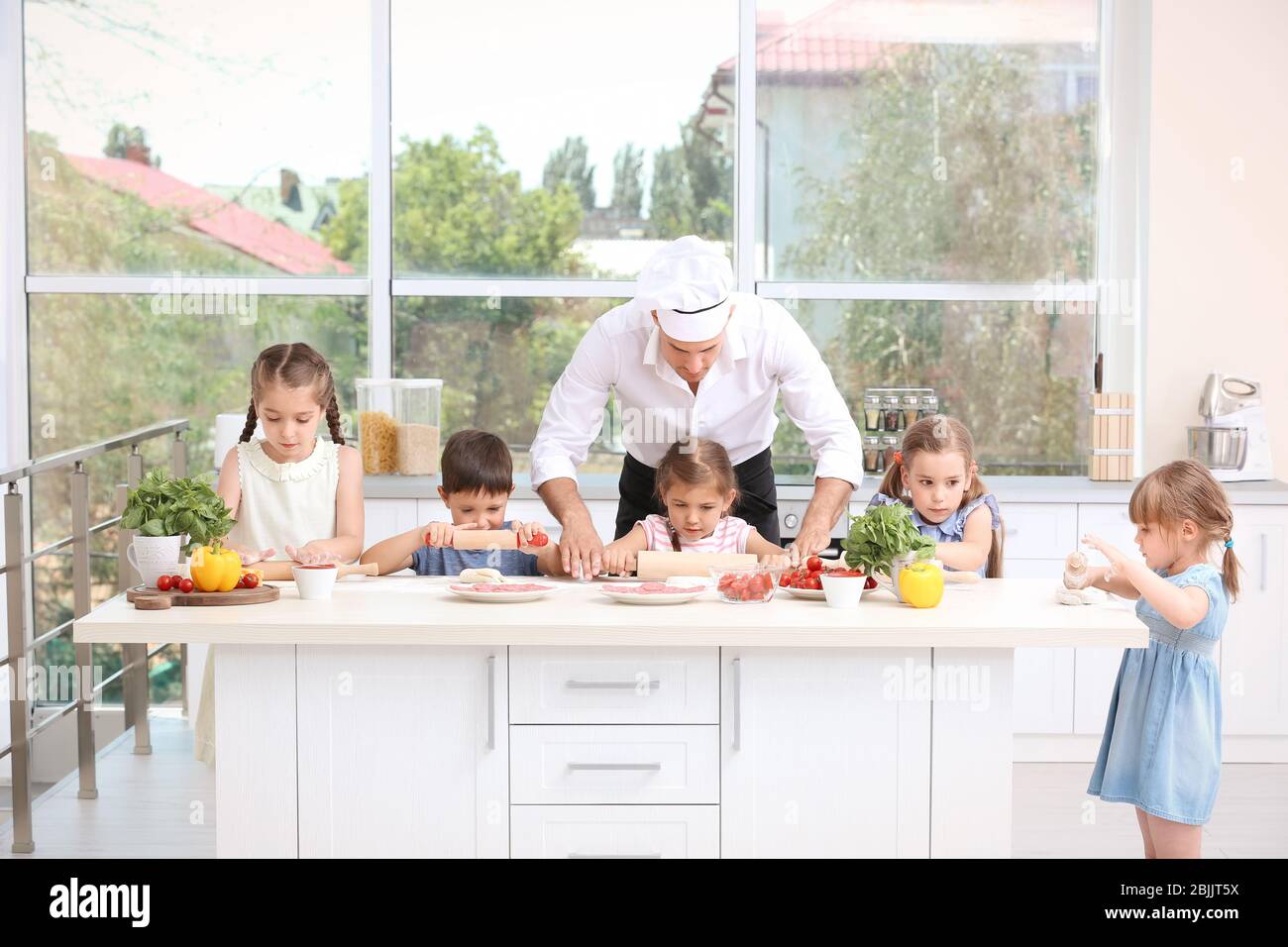 Group of children and teacher in kitchen during cooking classes Stock ...