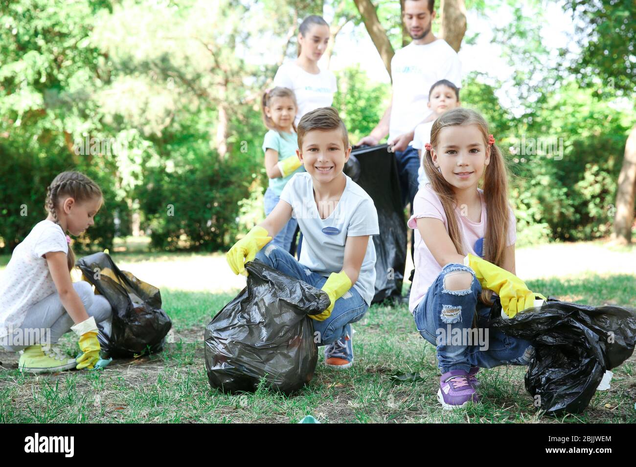 Young volunteers and children collecting garbage in park Stock Photo