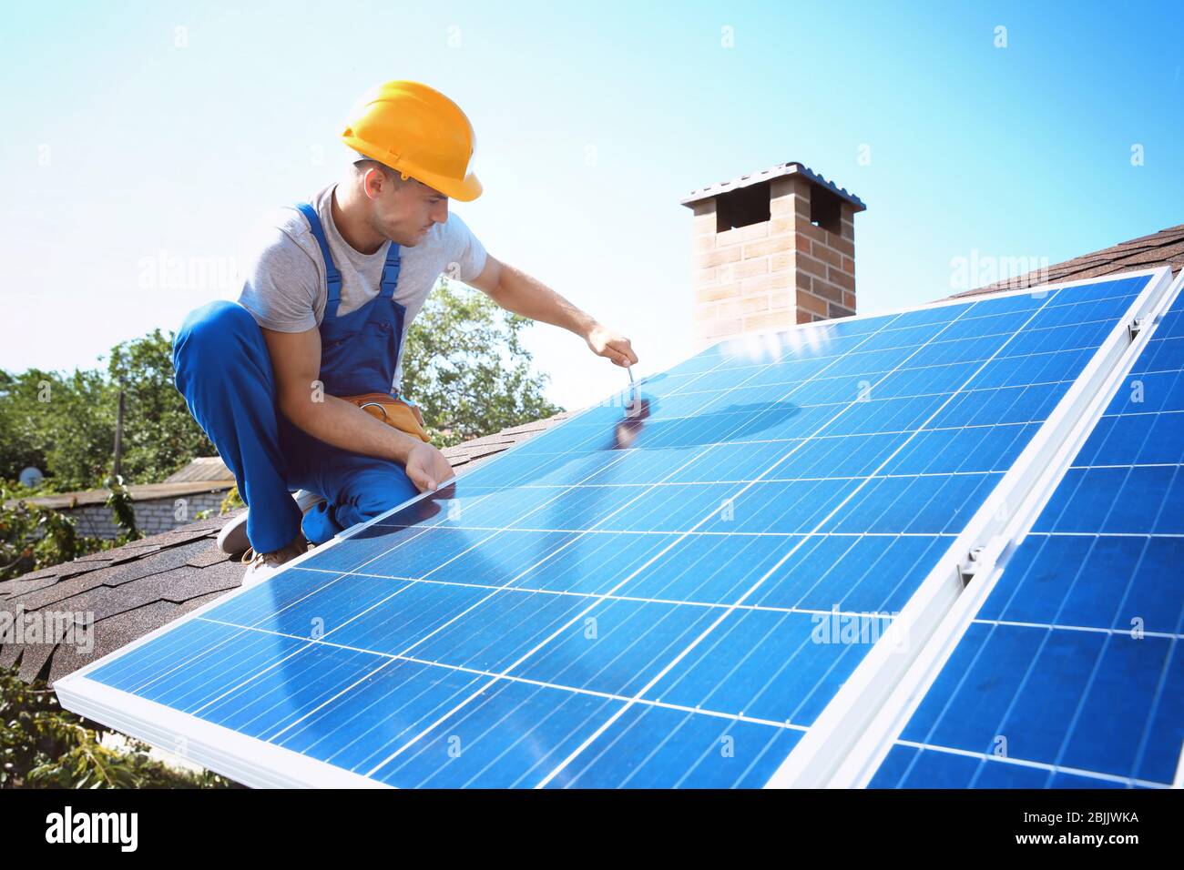 Worker installing solar panels outdoors Stock Photo