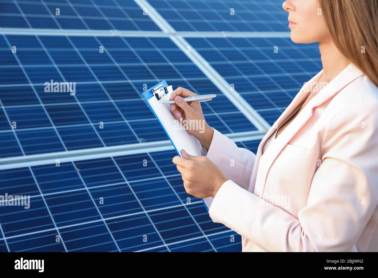 Female engineer developing project on installation of solar panels outdoors Stock Photo