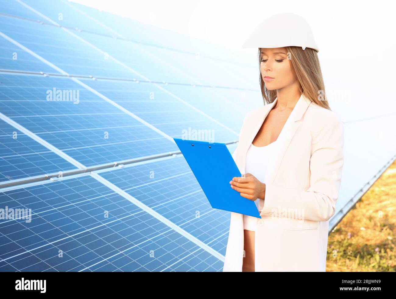 Female engineer developing project on installation of solar panels outdoors Stock Photo