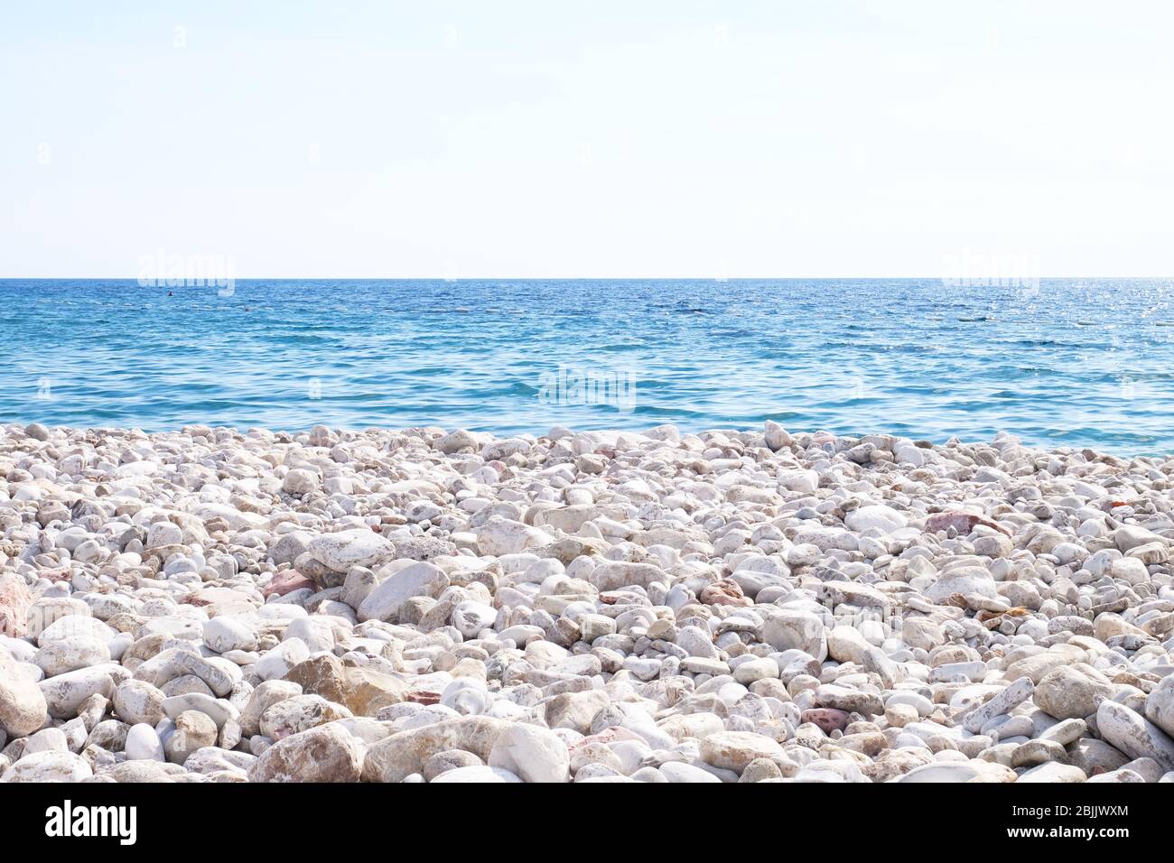 View of blue sea and rocky shore Stock Photo - Alamy