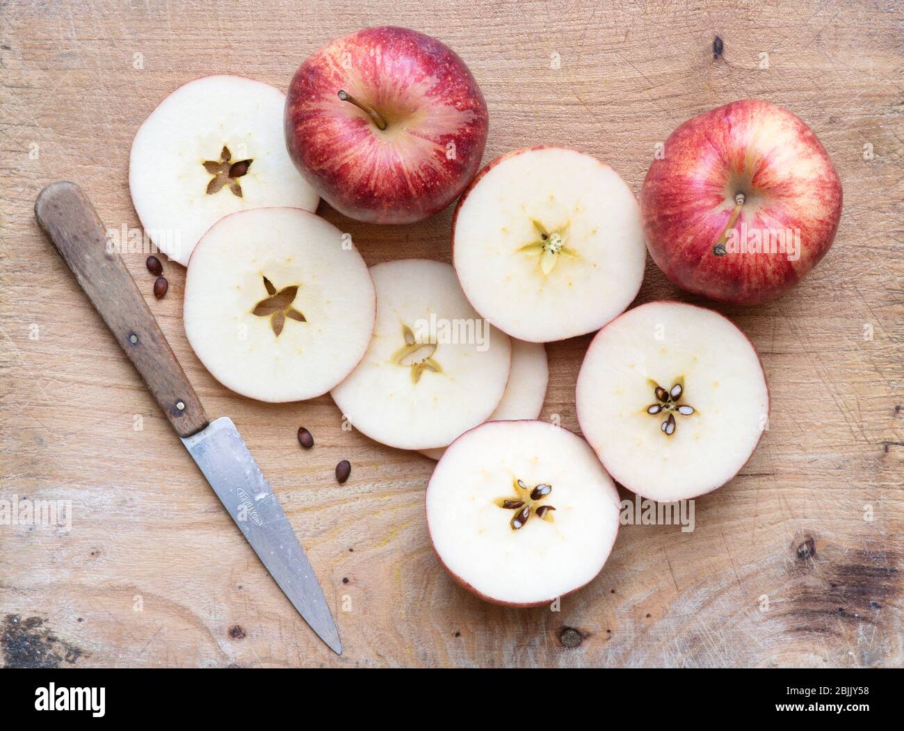 Malus Domestica. Red apple slices on a wooden board Stock Photo