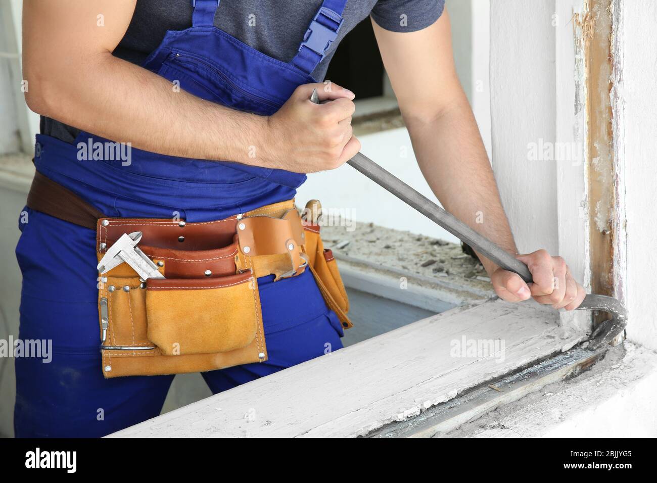 Worker repairing window in flat Stock Photo