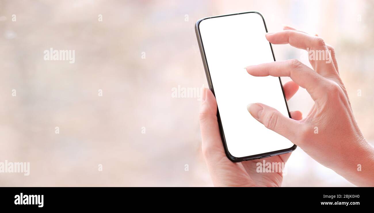 Female hand with smartphone, white blank screen with copy space. Stock Photo