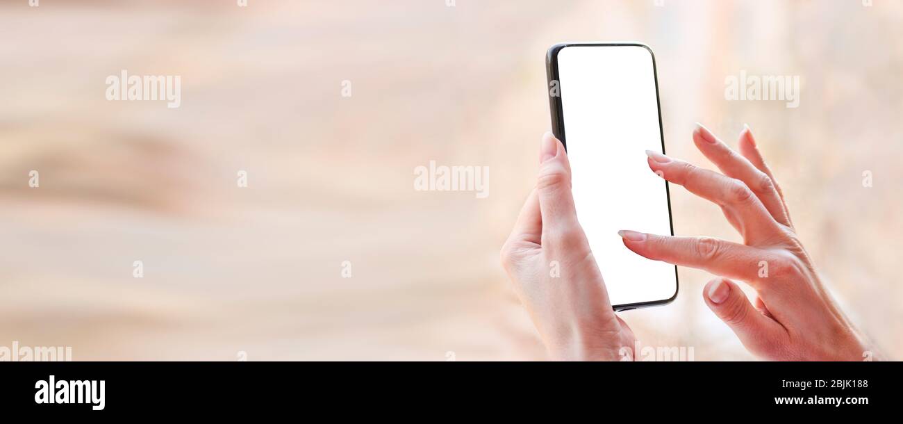 Female hand with smartphone, white blank screen with copy space. Stock Photo