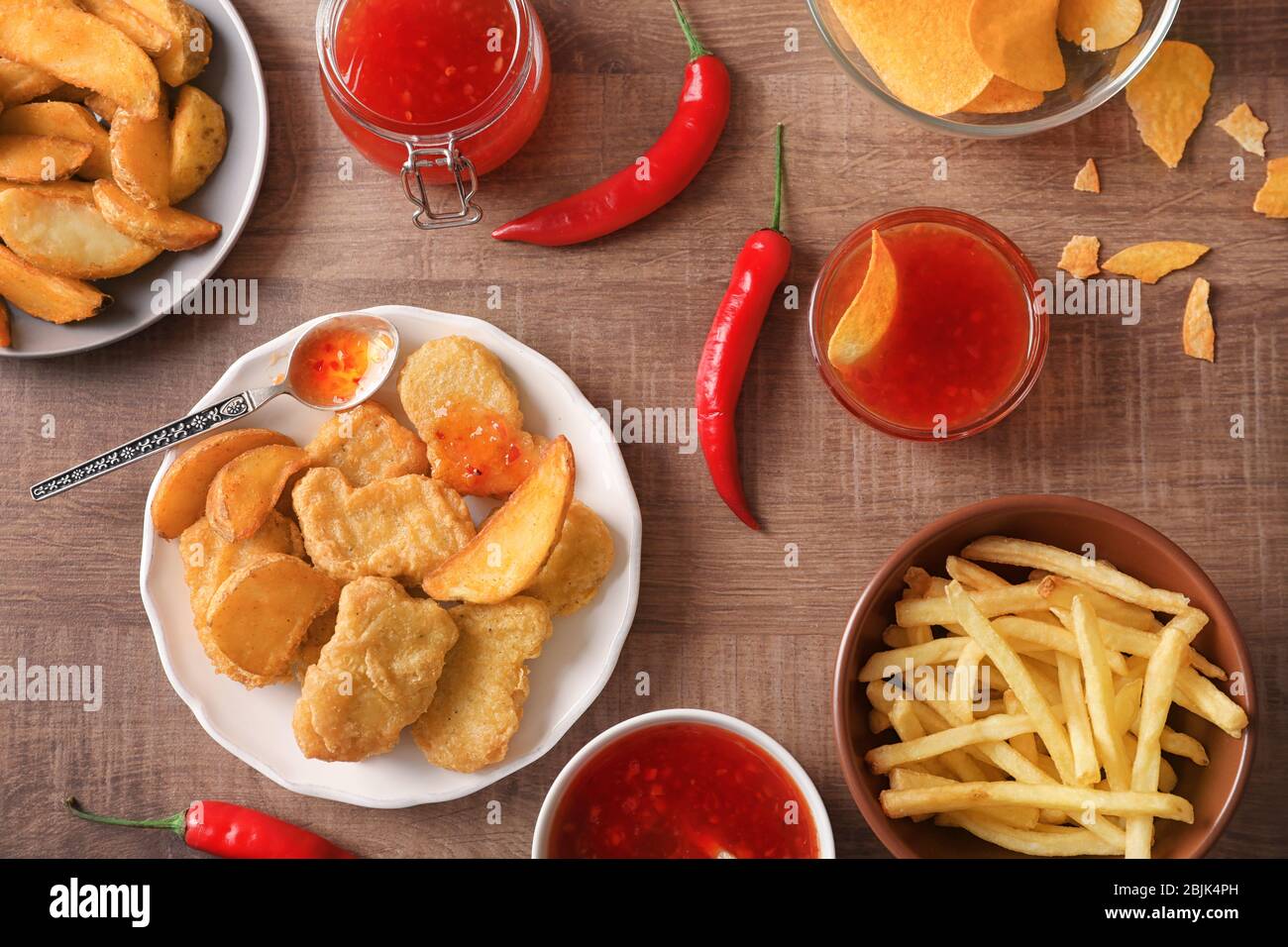 Fast food snacks with chili sauce on wooden background Stock Photo - Alamy