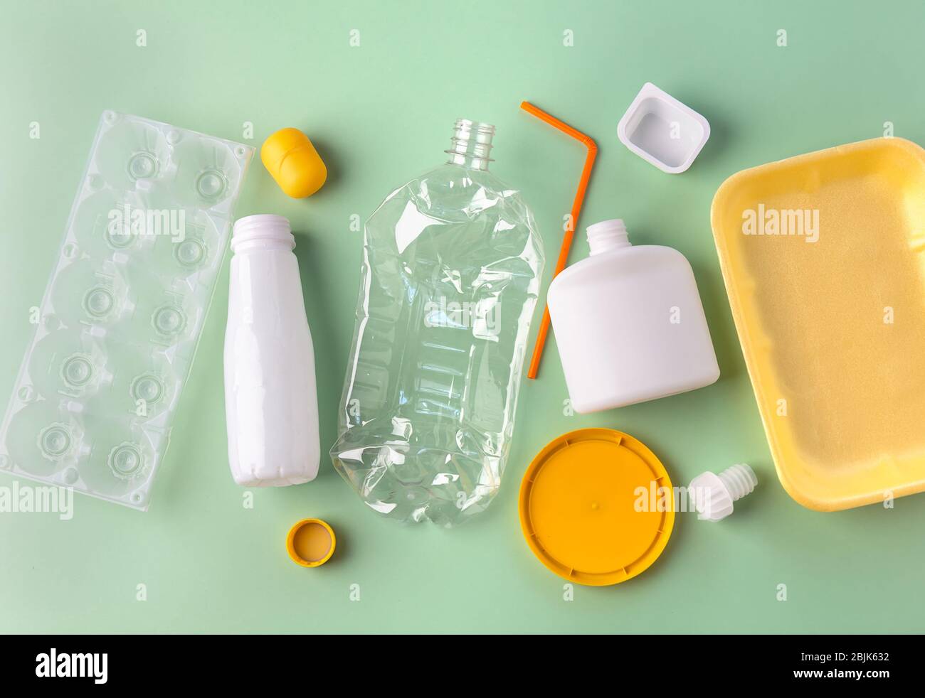 Recycled materials from different plastic on a green background. Zero waste concept. View from above Stock Photo