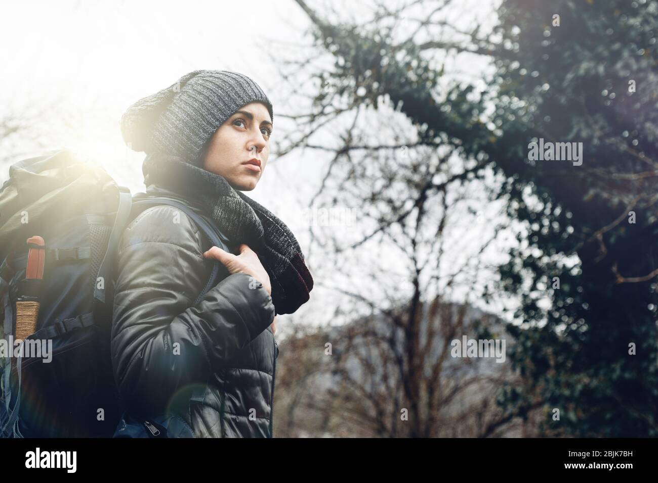 Young woman with backpack in forest. Concept Travel Tourism Adventure Hike and People Stock Photo