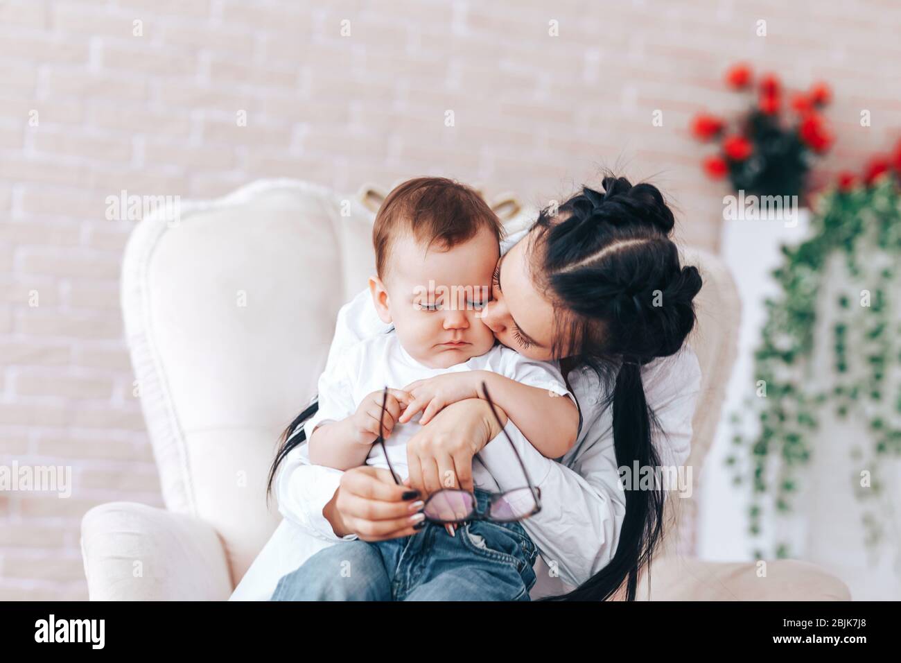 little boy with mom are sitting in a chair mom and son are hugging in a chair holding glasses in their hands advertising glasses what to do if poor 2BJK7J8