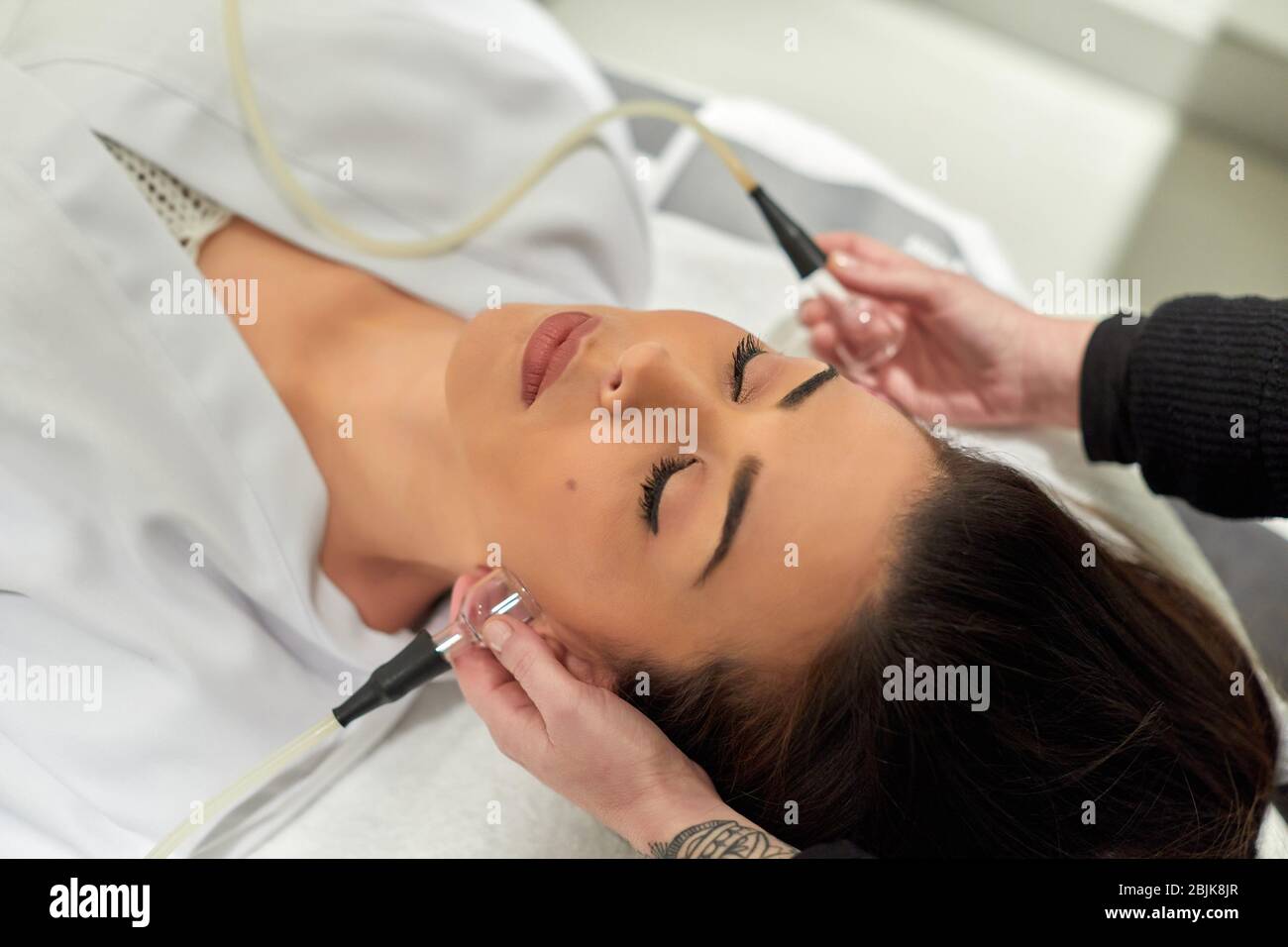 Beautician performing a face massage, hairdressing salon and beauty clinic. Stock Photo