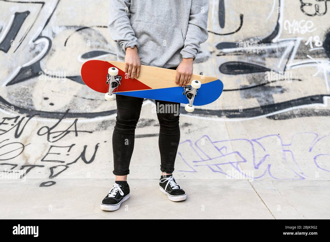 Close up of unrecognizable young man holding skateboard in the park. Stock Photo