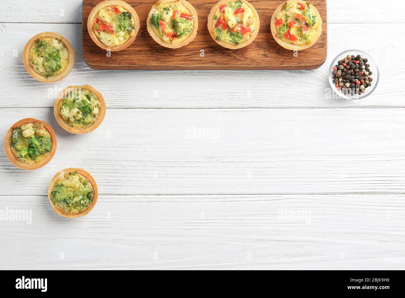 Composition with broccoli quiche tartlets on table Stock Photo