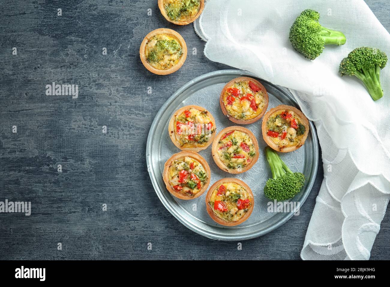 Composition with broccoli quiche tartlets on table Stock Photo