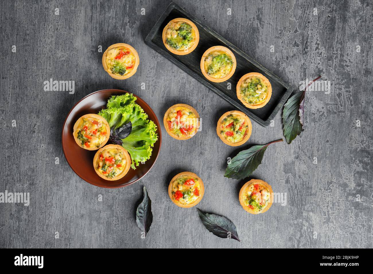 Composition with broccoli quiche tartlets on table Stock Photo