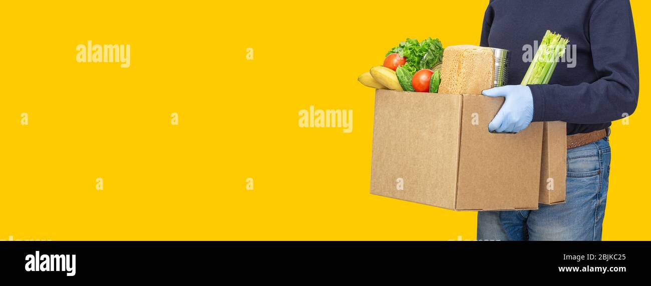 https://c8.alamy.com/comp/2BJKC25/delivery-man-holding-cardboard-boxes-in-medical-rubber-gloves-online-shopping-and-express-delivery-food-delivery-service-volunteer-brings-a-donatio-2BJKC25.jpg