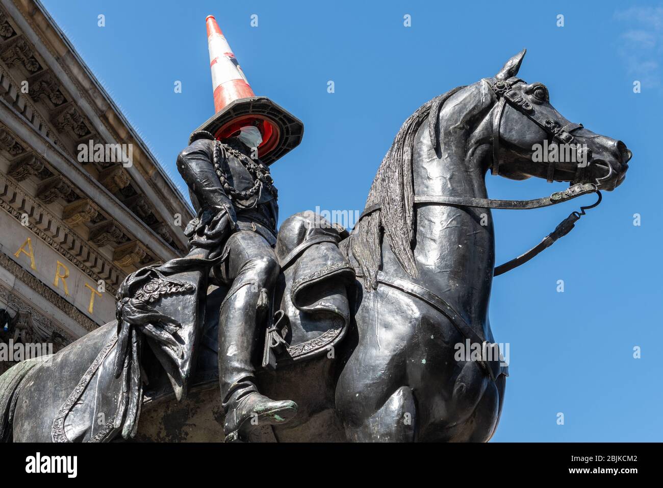 Coronavirus pandemic Glasgow Scotland UK - iconic Duke of Wellington statue wearing a face mask as well as his usual cone Stock Photo