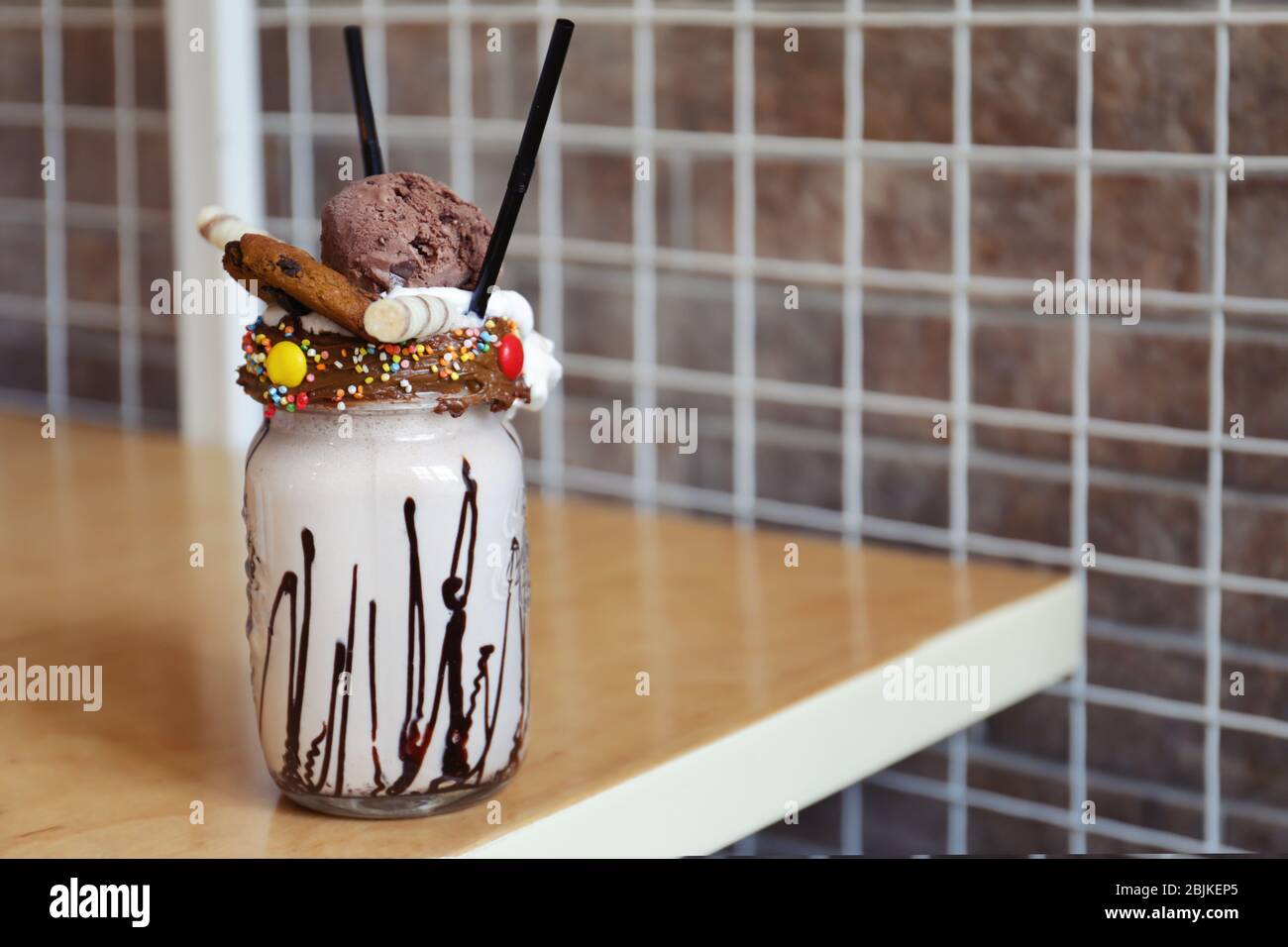 https://c8.alamy.com/comp/2BJKEP5/delicious-milk-cocktail-with-various-toppings-in-mason-jar-on-table-2BJKEP5.jpg