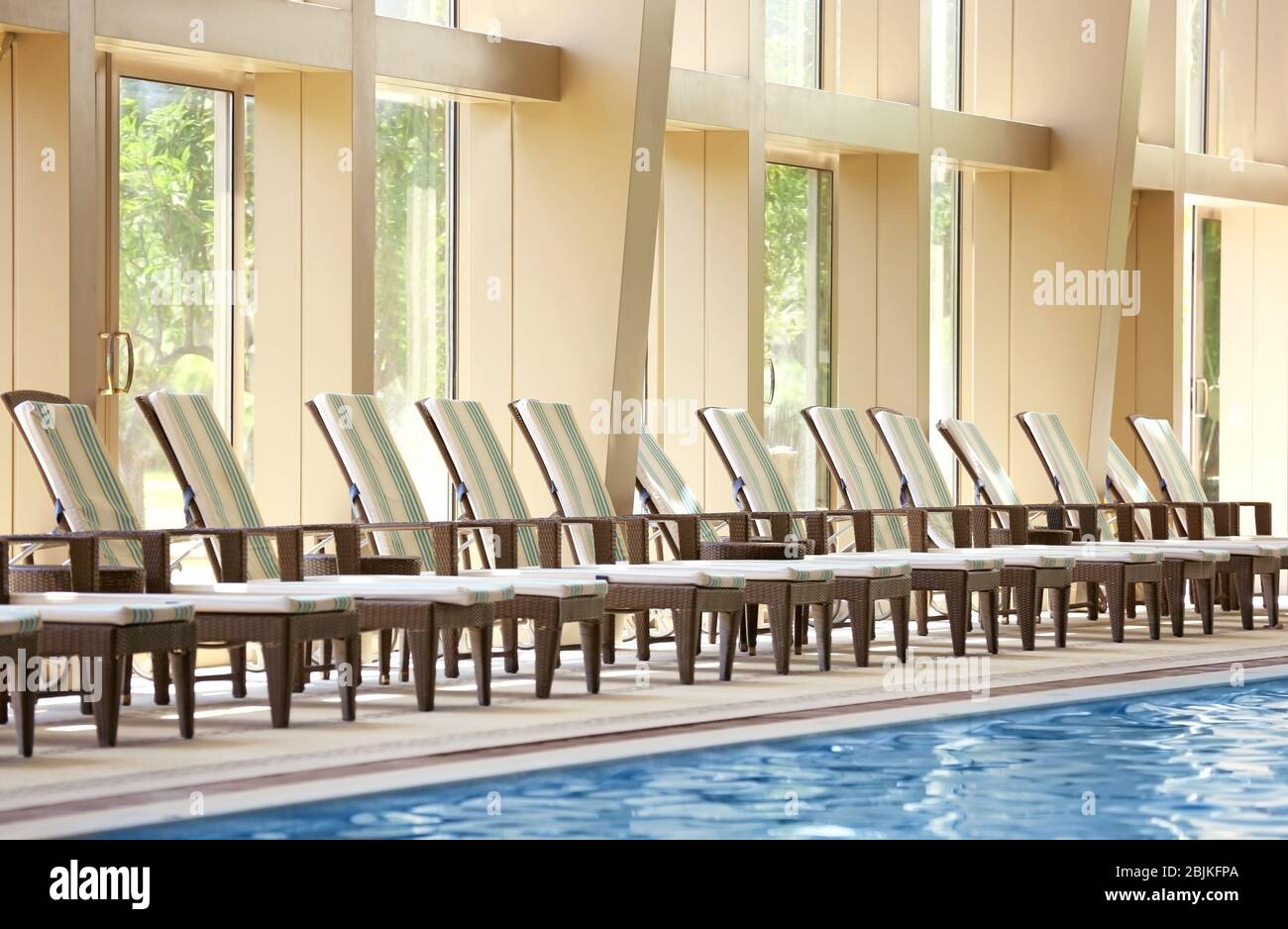Chaise lounges near swimming pool in luxury hotel Stock Photo Alamy