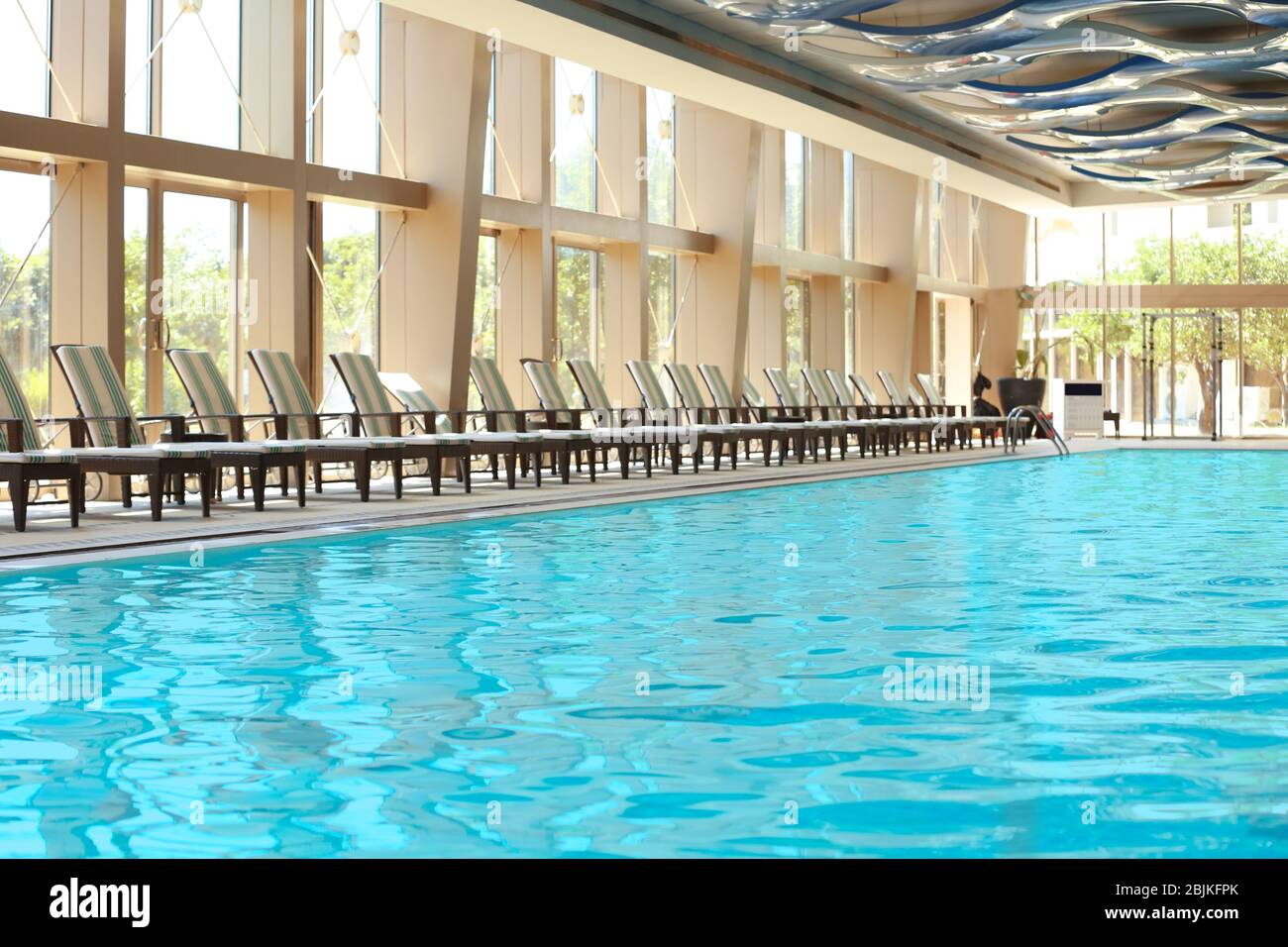 Chaise lounges near swimming pool in luxury hotel Stock Photo Alamy