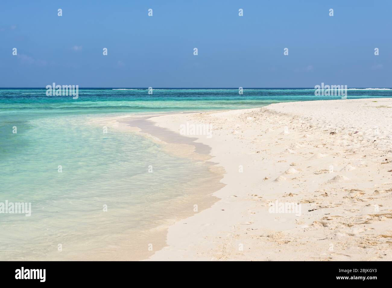 Amazing empty wild beach with turquoise water and white sand. Picturesque seascape with blue sky. Maafushi Island, Maldives, Indian Ocean. Stock Photo