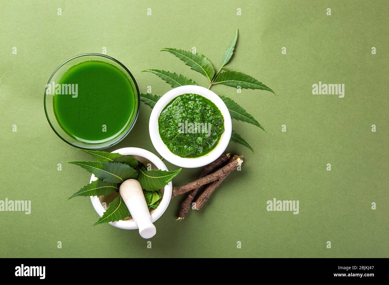 Medicinal Neem Leaves In Mortar And Pestle With Neem Paste Juice And Twigs On Green Background 4687