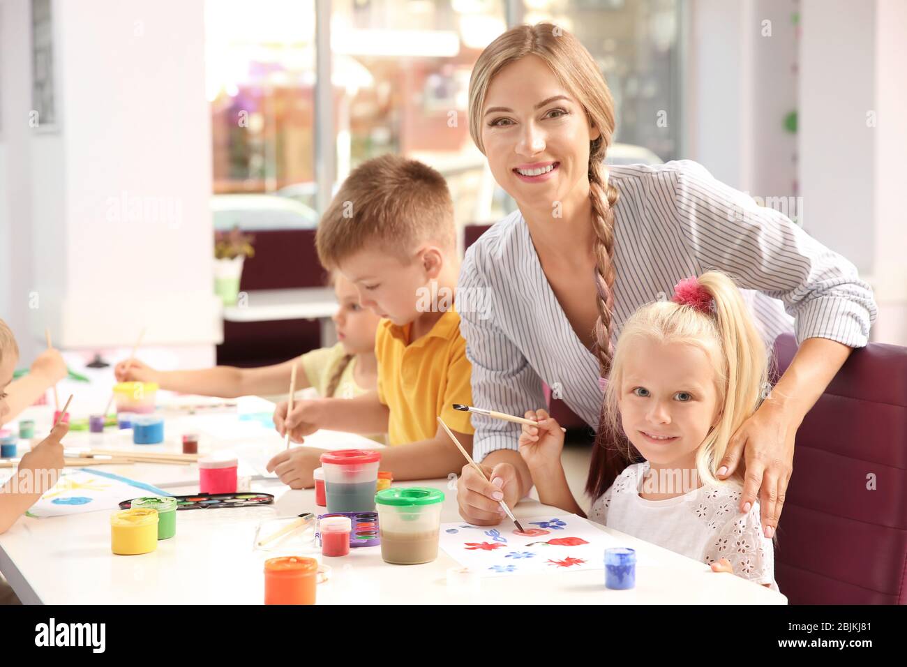 Children with teacher at painting lesson in classroom Stock Photo - Alamy