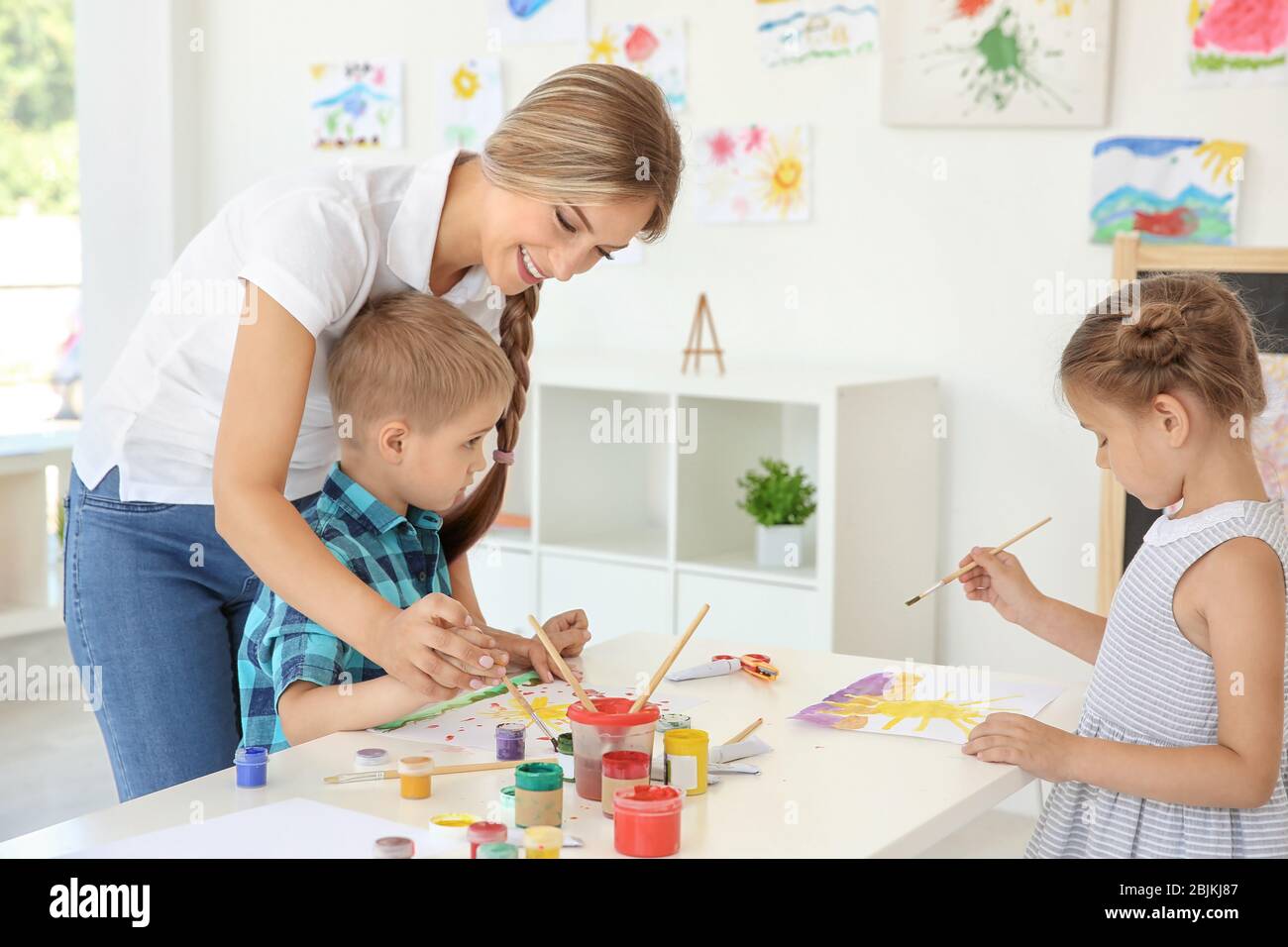 Children with teacher at painting lesson in classroom Stock Photo - Alamy