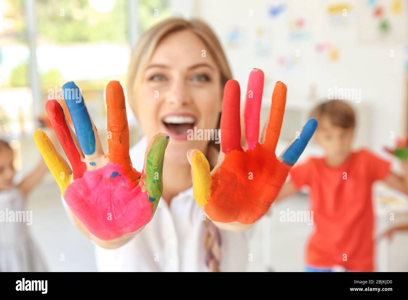 Young female art teacher with hands in paint indoors Stock Photo Alamy