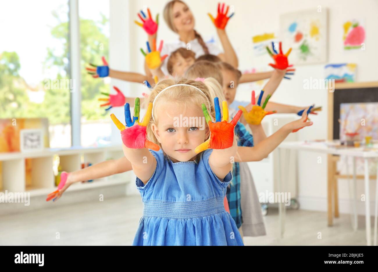 Children and teacher with hands in paint at art lesson Stock Photo Alamy
